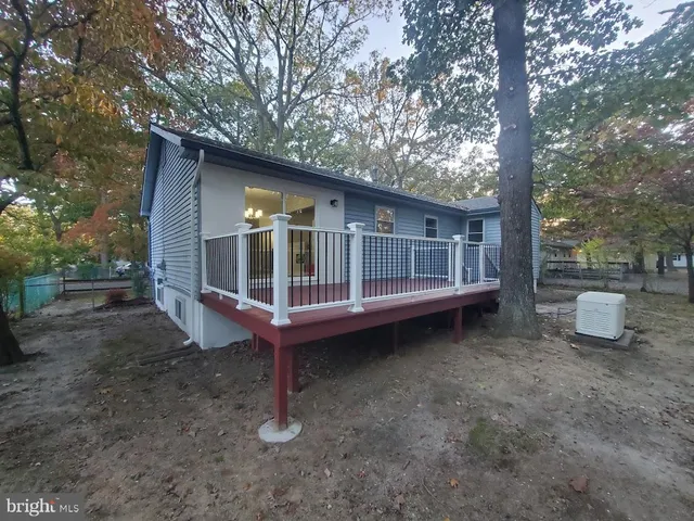 a view of a house with a yard and wooden fence