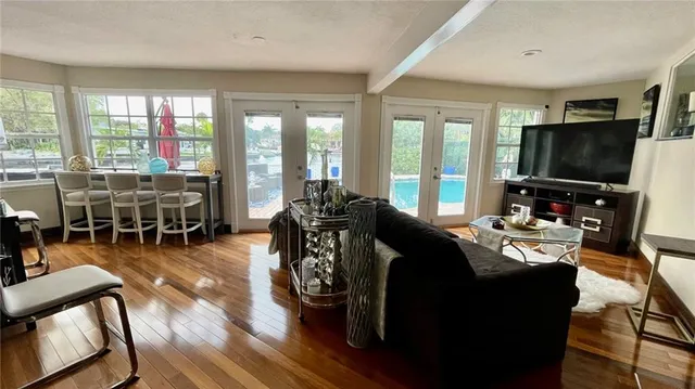 a living room with furniture a flat screen tv and large windows