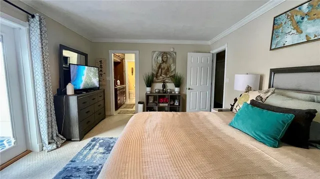 a large bedroom with a bed and wooden floor