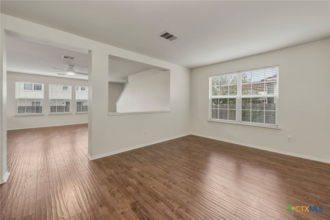 109 Comal Cove Elgin, TX 78621 - Photo 3 of 34 an empty room with wooden floor and windows