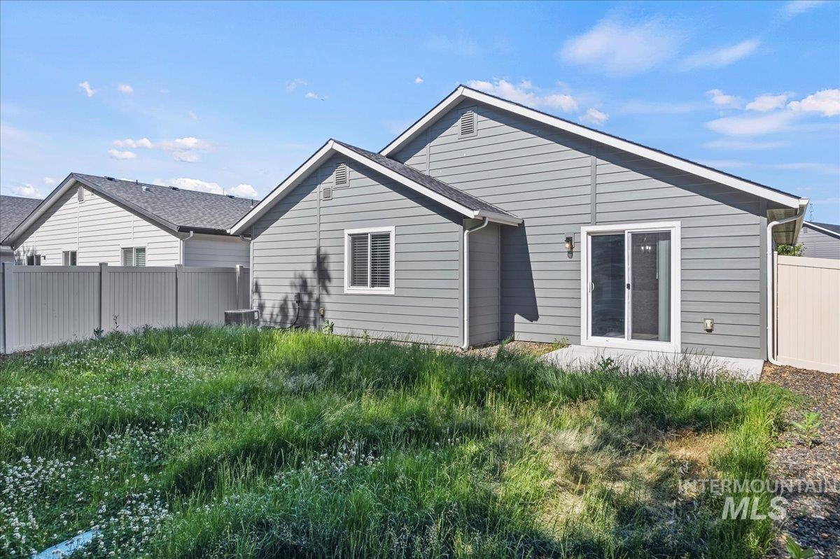 3091 S Green Boise, ID 83709 - Photo 24 of 27 Expansive backyard featuring a manicured lawn, a concrete patio, and a privacy fence