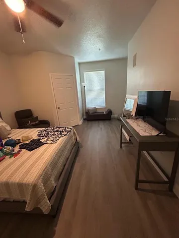 a bedroom with a bed and wooden floor