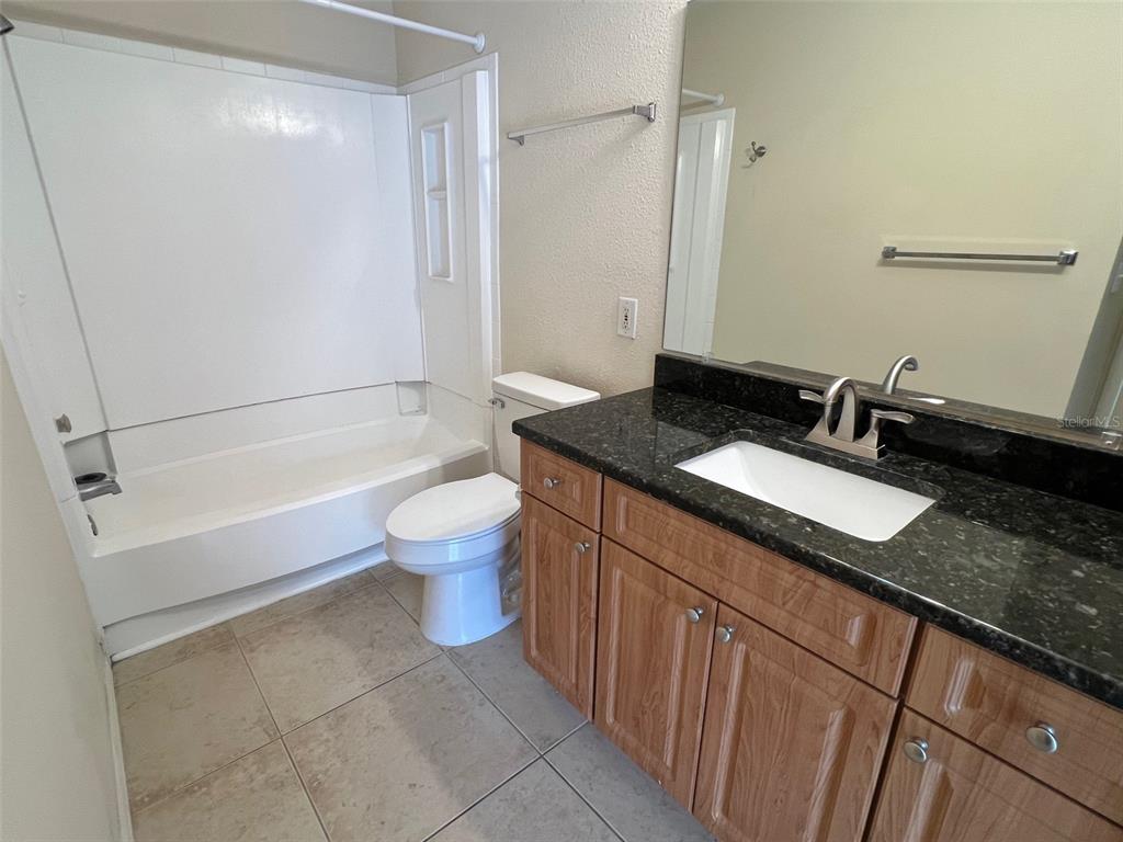 455 Alt 19, Unit 159 Palm Harbor, FL 34683 - Photo 16 of 26 a bathroom with a granite countertop sink a toilet a mirror and shower