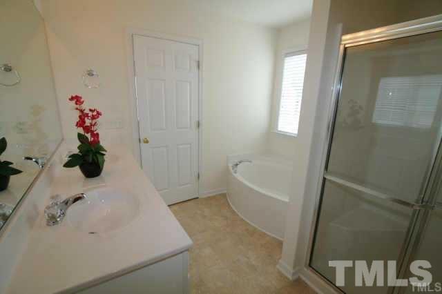 305 Rapp Lane Apex, NC 27502 - Photo 3 of 5 a bathroom with a tub shower and a sink