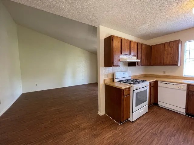 a kitchen with wooden floors and wooden cabinets