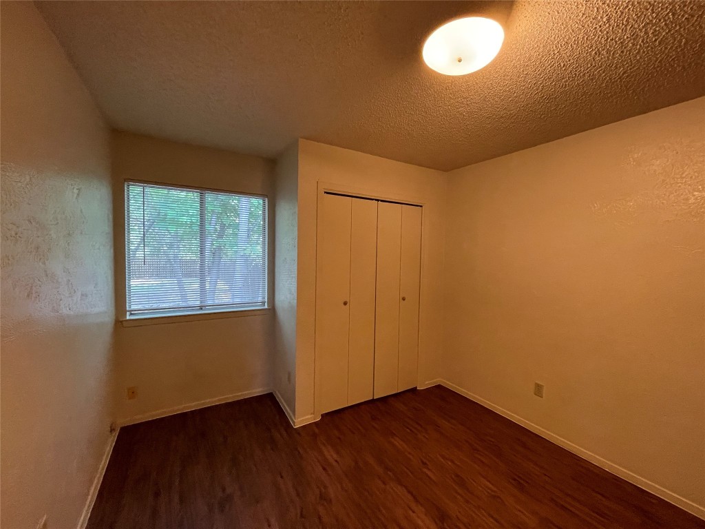 7902 Brodie Lane, Unit A Austin, TX 78745 - Photo 14 of 22 a view of an empty room with wooden floor and a window