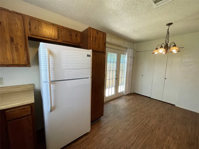 a kitchen with wood floors and refrigerator