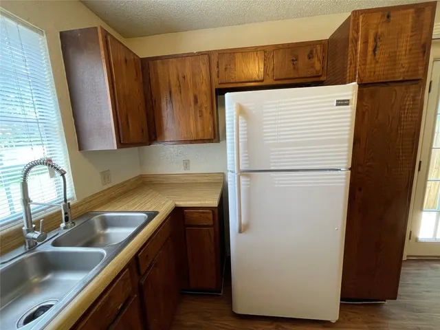 a kitchen with a refrigerator sink and cabinets