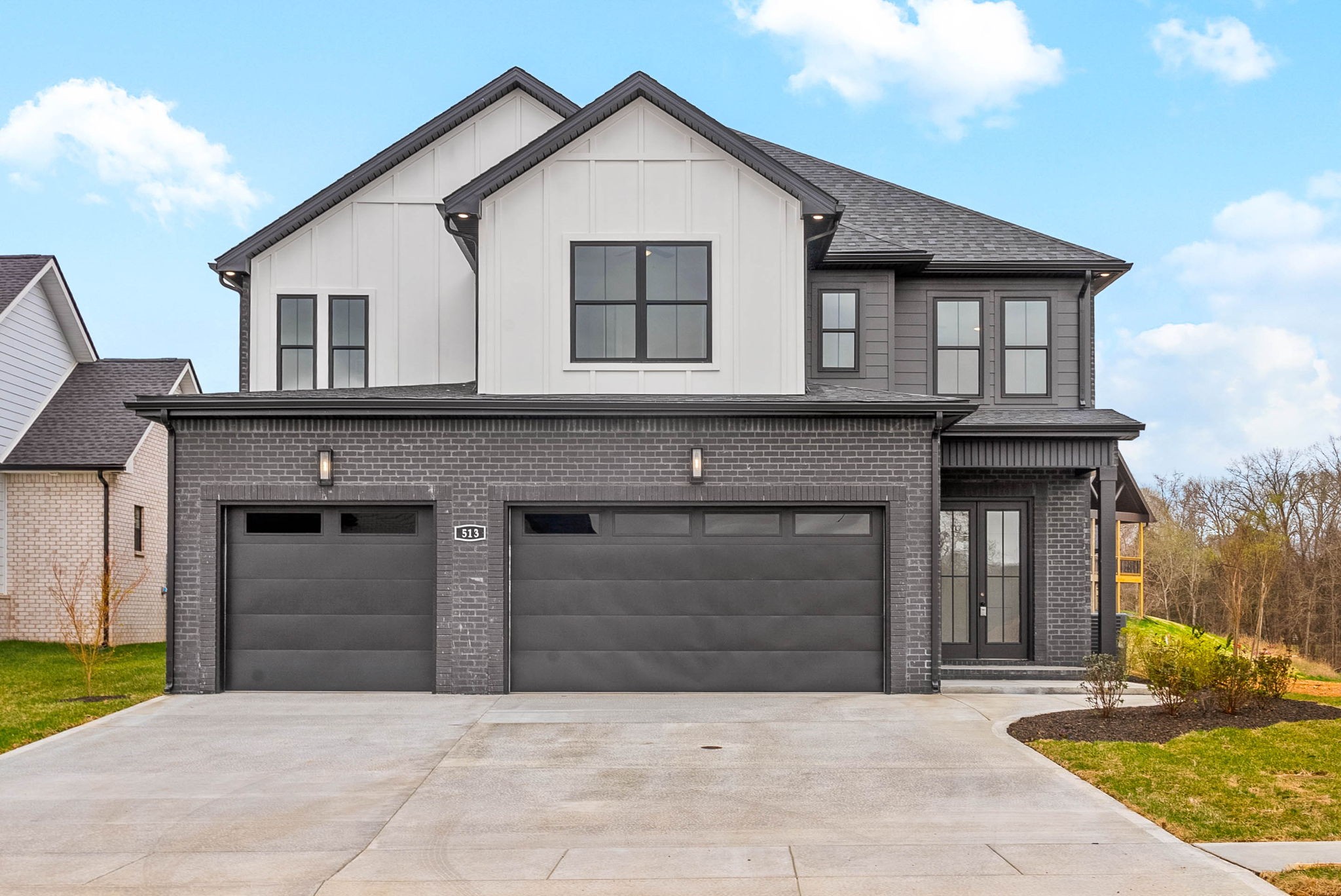 a front view of a house with yard and parking