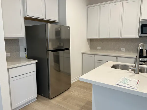 a kitchen with stainless steel appliances a refrigerator a sink and cabinets