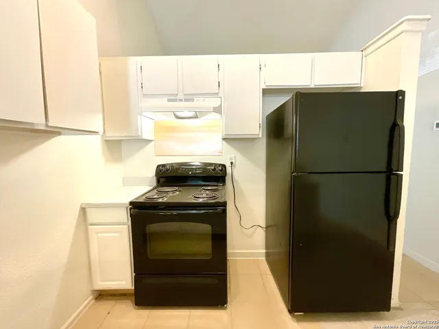 a view of a room with a chandelier fan and windows