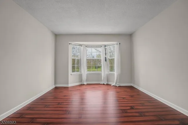 a view of room with window and wooden floor