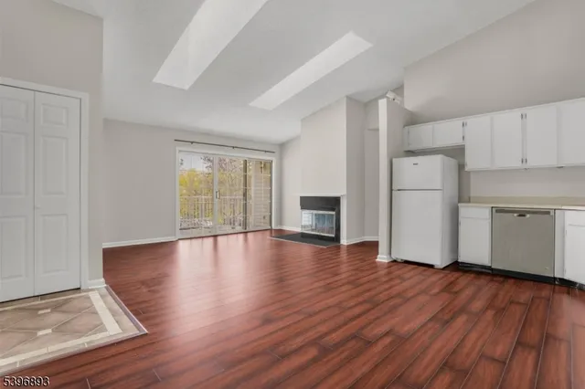 a view of empty room with wooden floor and window