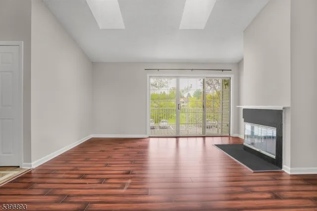 a view of empty room with wooden floor and fireplace