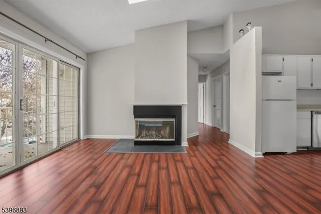 a view of a livingroom with wooden floor and a fireplace