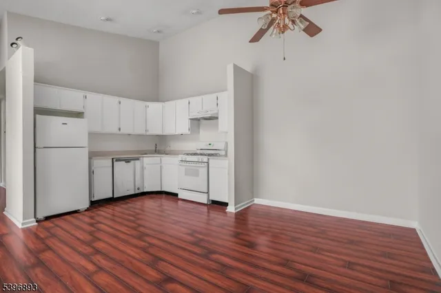 a view of kitchen with stainless steel appliances granite countertop a stove a refrigerator and a chandelier