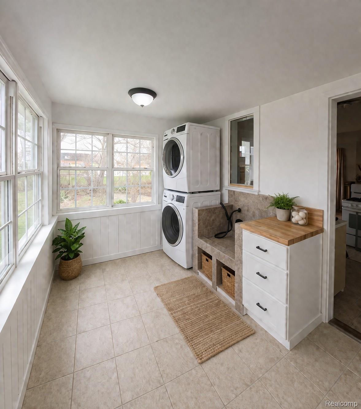 5815 Chicago Road Warren, MI 48092 - Photo 40 of 47 Laundry area with stacked washing machine and dryer and light tile patterned flooring