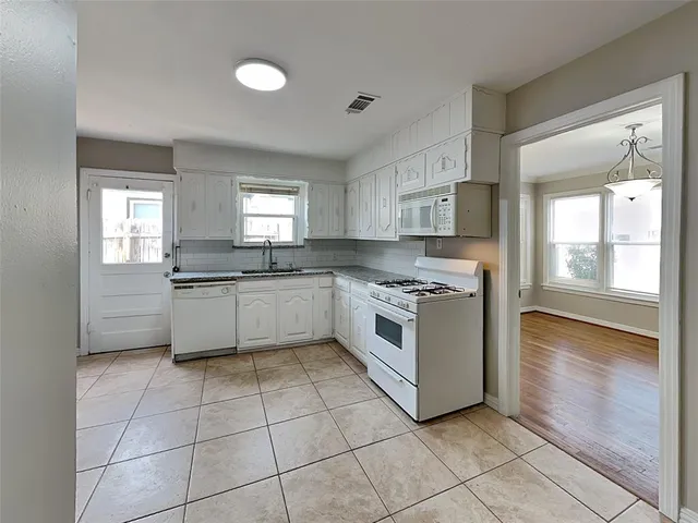 a kitchen with a stove sink and cabinets