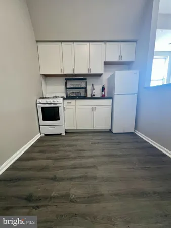 a kitchen with granite countertop white cabinets and white appliances
