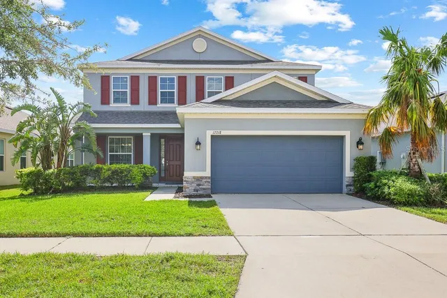 a front view of a house with a yard and garage