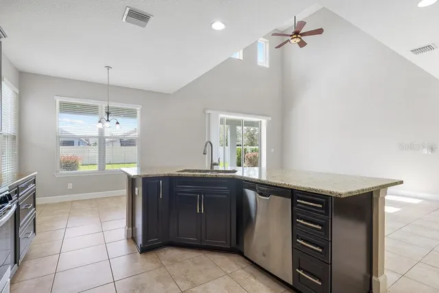 a kitchen with granite countertop a refrigerator and a sink