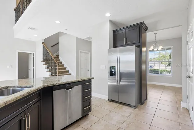 an empty room with chandelier fan and windows