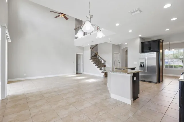 a view of kitchen with stainless steel appliances cabinets and ceiling fans
