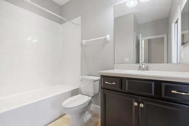 an empty room with a chandelier fan and windows