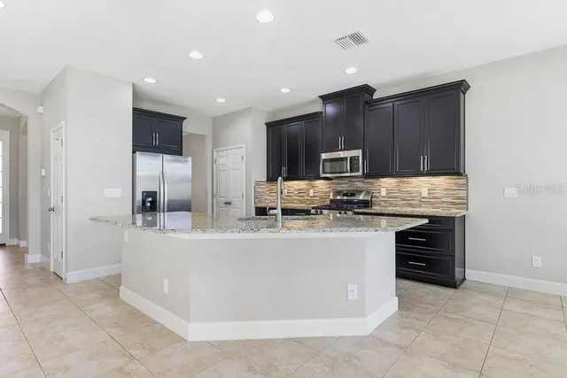 a kitchen with granite countertop stainless steel appliances and wooden cabinets