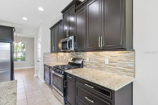a kitchen with stainless steel appliances granite countertop a sink and a stove