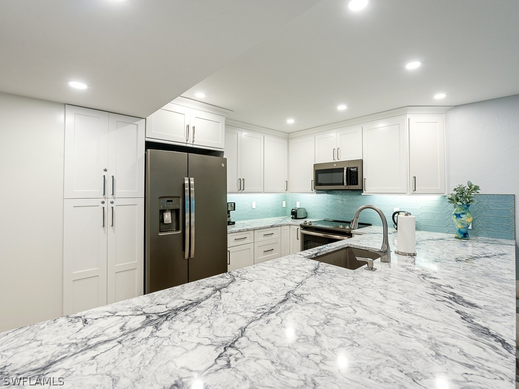 760 Sextant Drive, Unit 732 Sanibel, FL 33957 - Photo 15 of 35 a kitchen with granite countertop a refrigerator and a sink