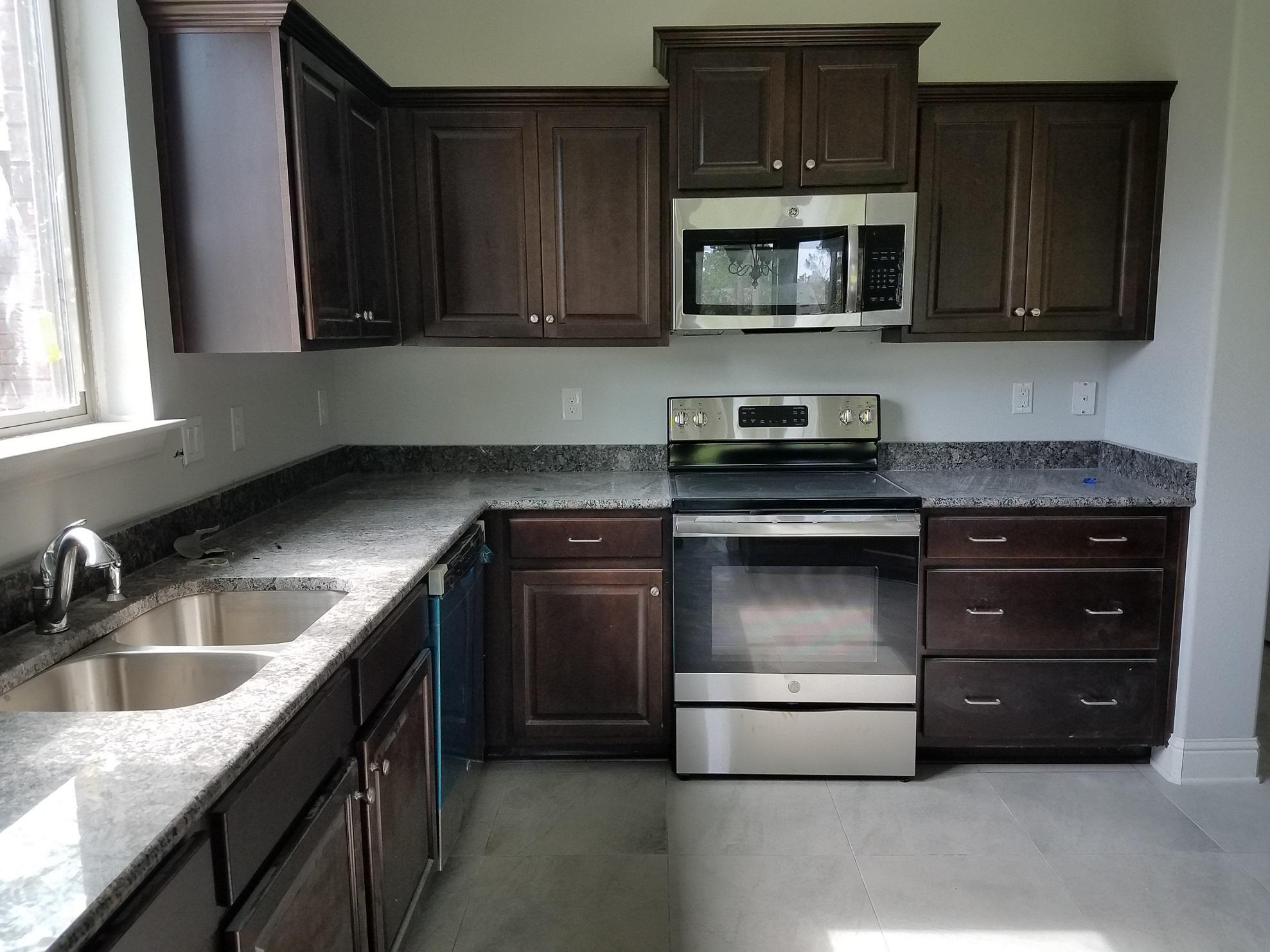 2399 Cove Road Navarre, FL 32566 - Photo 6 of 7 a kitchen with granite countertop a stove and a sink