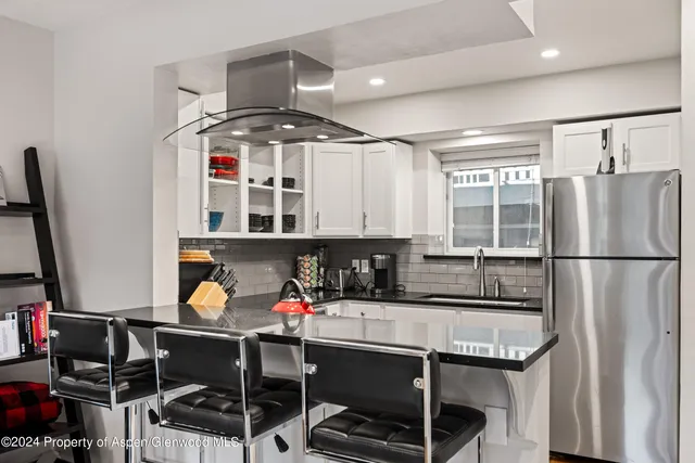 a kitchen with stainless steel appliances a sink and a refrigerator