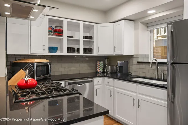 a kitchen with stainless steel appliances granite countertop a sink stove and cabinets