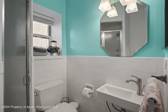 a bathroom with a sink a toilet and mirror