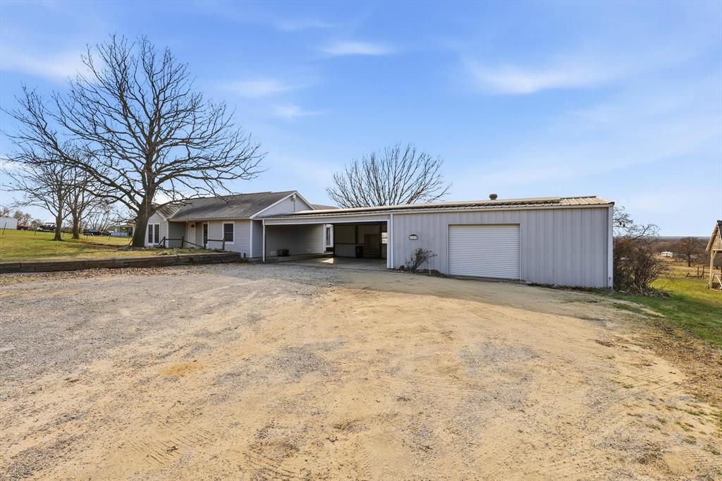 123 Valley Ranch Road Sherman, TX 75092 - Photo 2 of 40 View of front of house featuring dirt driveway, a garage, and a patio area