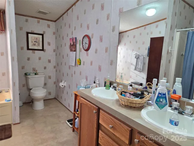 a bathroom with a granite countertop sink mirror vanity and toilet