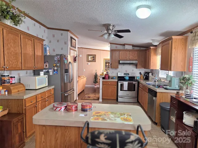 a kitchen with stainless steel appliances granite countertop a stove refrigerator and cabinets