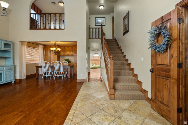 892 Cambridge Drive St. George, UT 84770 - Photo 7 of 65 Entryway featuring tile flooring, a carpeted staircase with wood railing, and a solid wood front door