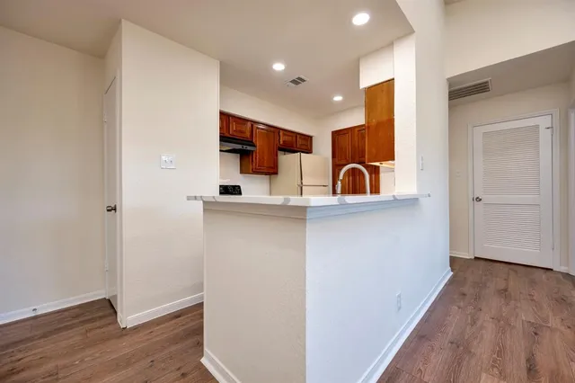 a view of a kitchen with a sink and dishwasher with wooden floor