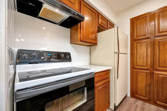 a kitchen with stainless steel appliances granite countertop a refrigerator and a stove top oven