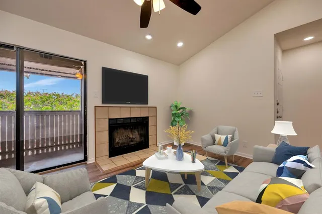 a living room with furniture a fireplace and a flat screen tv