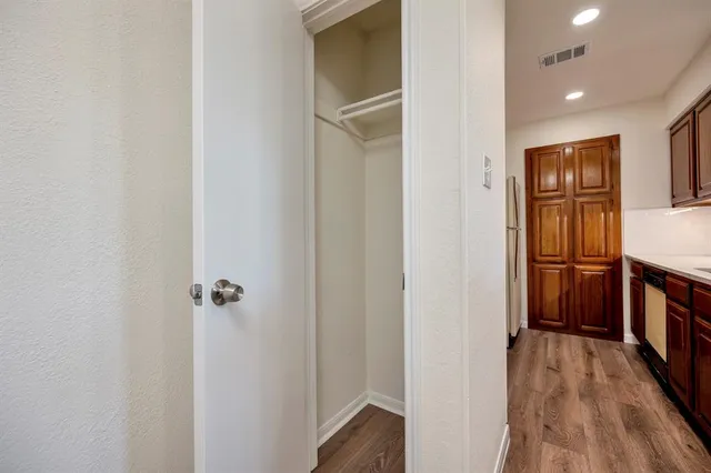 a view of a hallway with closet and wooden floor