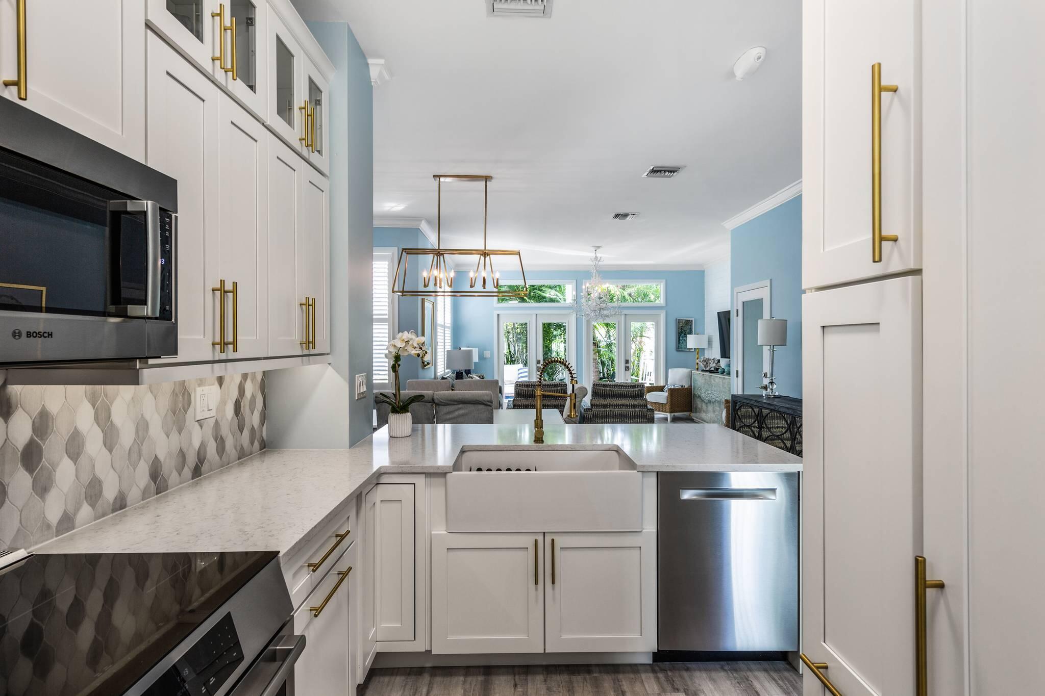 216 Fleming Street Key West, FL 33040 - Photo 13 of 33 a kitchen with kitchen island granite countertop a sink and white cabinets