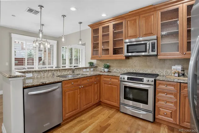 a kitchen with stainless steel appliances granite countertop a stove and cabinets