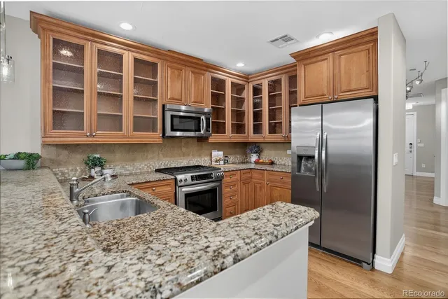 a kitchen with stainless steel appliances granite countertop a sink stove and refrigerator