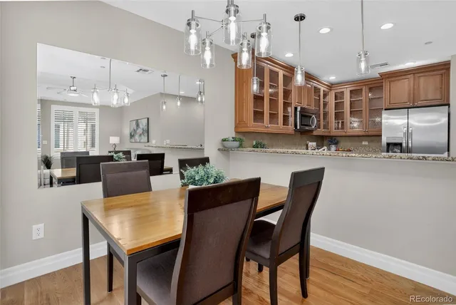 a kitchen with granite countertop a table chairs microwave and cabinets