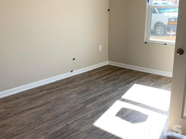 a view of an empty room and wooden floor