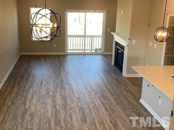 an entryway with wooden floor a fireplace and windows