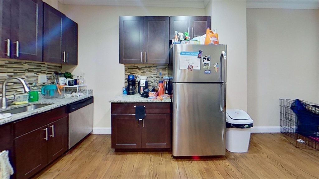 2975 Washington Street, Unit 1 Boston, MA 02119 - Photo 1 of 8 a kitchen with a refrigerator and wooden floor
